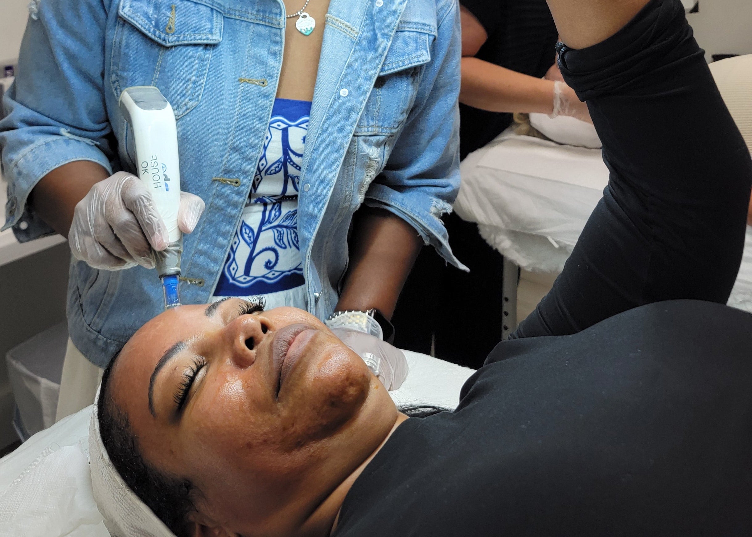 Person receiving a facial treatment with a professional in a clinical setting.